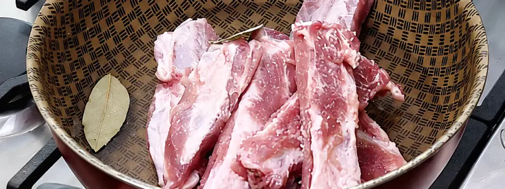 Costillas de cerdo cociéndose con laurel y sal