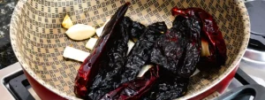 Chiles para adobo con ajo y cebolla dorándose
