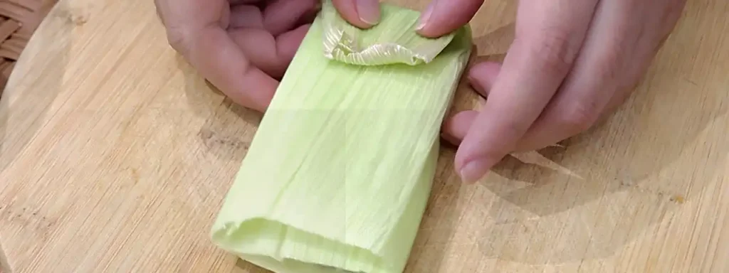 Doblar la hoja de elote para cerrar el tamal