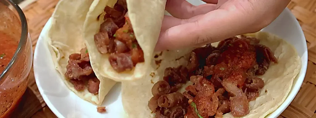 Tacos de tripa con salsa tatemada, sal y limón