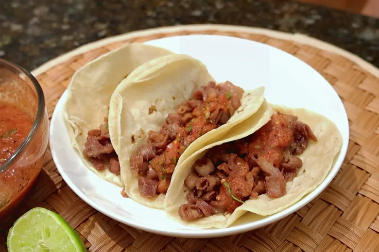 Tacos de tripa de res servidos con salsa y limón