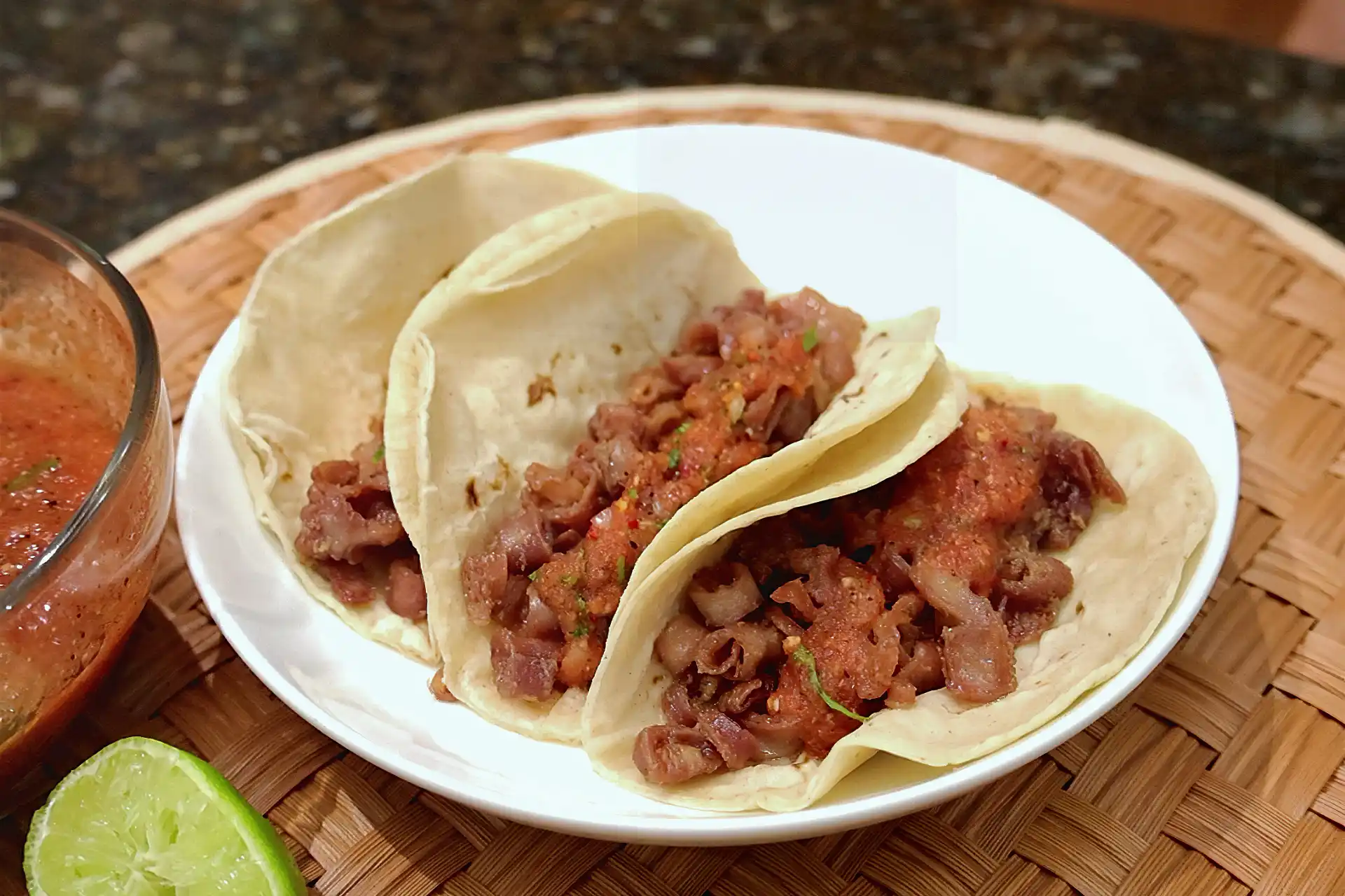 Tacos de tripa de res servidos con salsa y limón