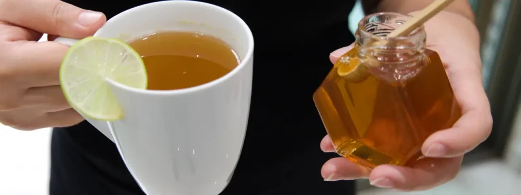 Té de limón con miel y frasco con miel